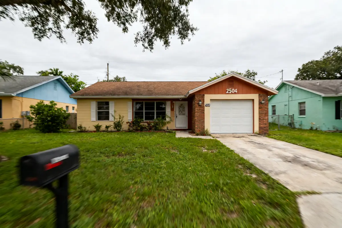 Suburban house with garage and lawn, address number 2504 prominently displayed