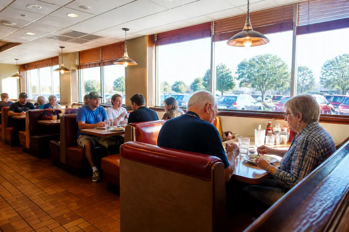 Customers dining inside Denny's in Waukesha, enjoying meals at booth seating