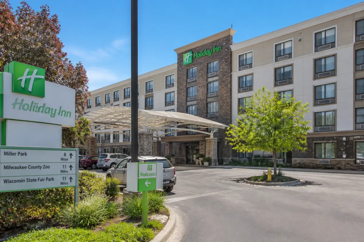 Front entrance of Holiday Inn in Pewaukee with decorative overhang and directional signs